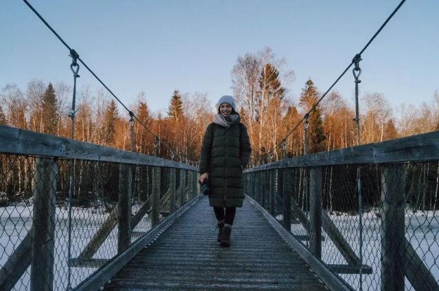 Frau steht auf einer Hängebrücke