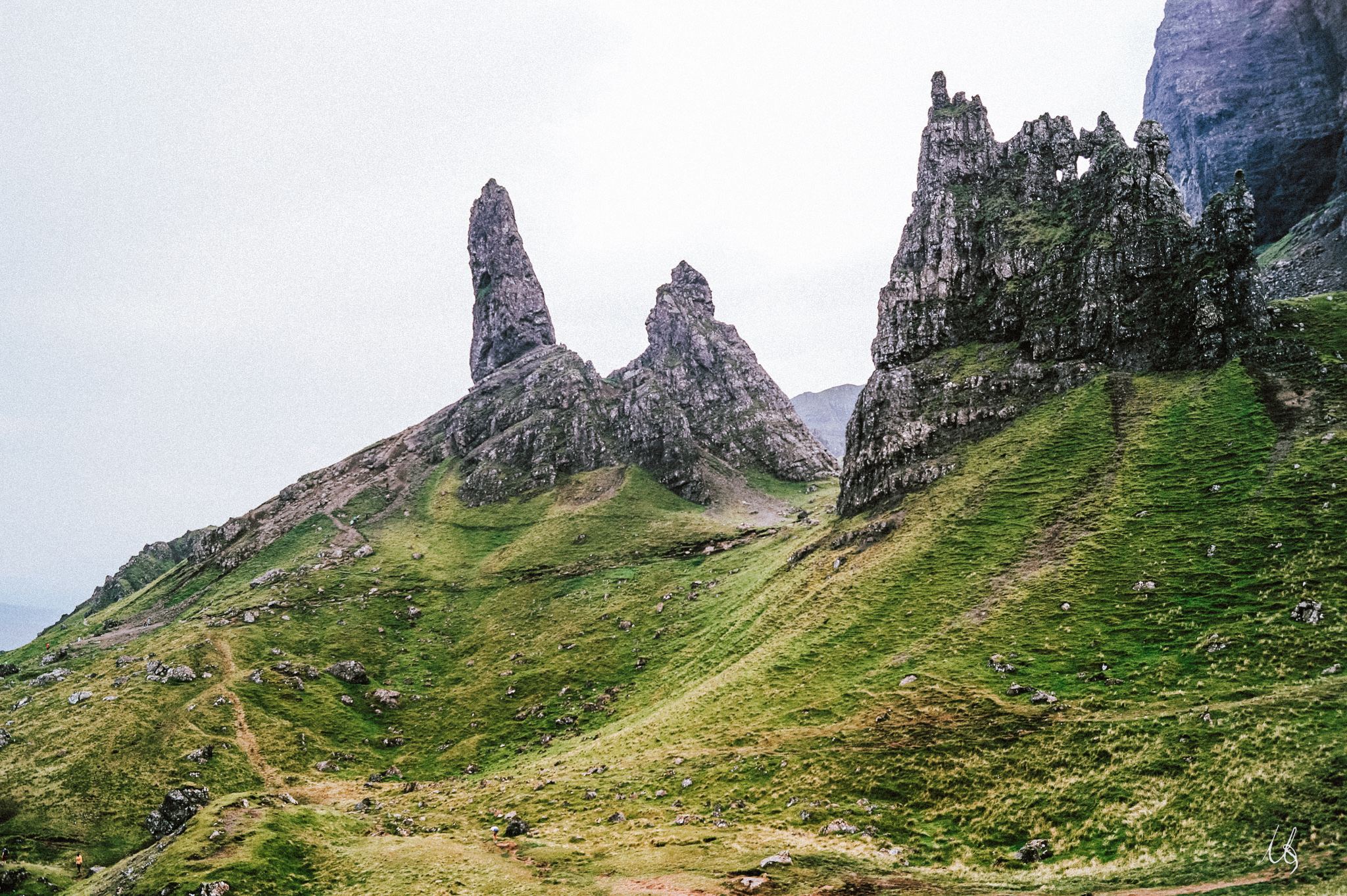 Zerkklüftete Felsen auf mit Wiesen bewachsenen Hängen