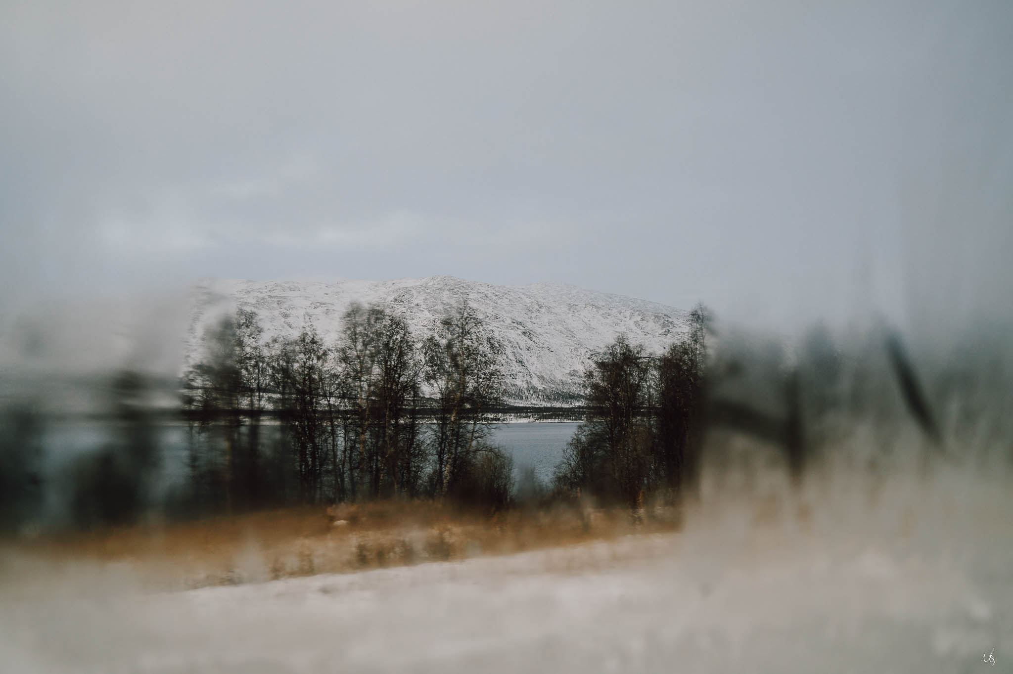 Blick durch ein vereistes Fenster auf einen See